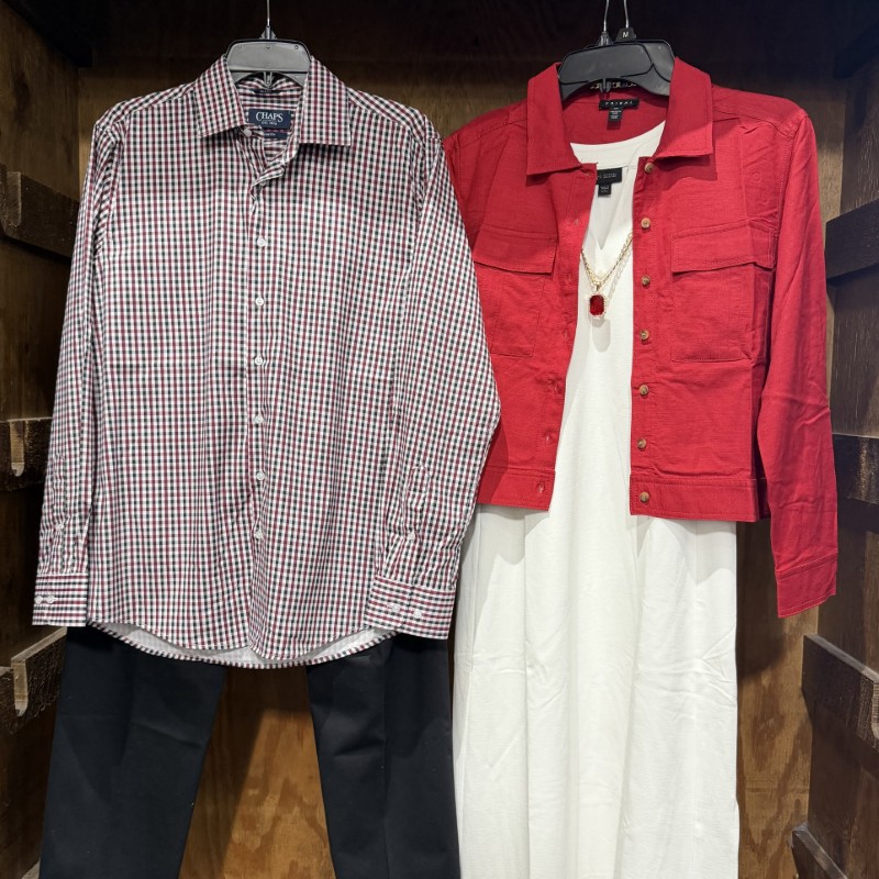 Image of a woman's white dress with a red jacket over top next to a men's plaid button down and black pants.